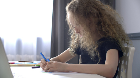 卷曲的女孩少年在窗口背景的纸页上绘制素描彩色标记女视频