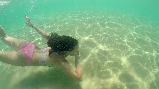 时装模特儿少女在水下游泳闷闷的闭着鼻子慢动作视频
