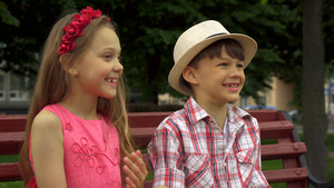 小女孩和坐在长凳上的男孩分享秘密11秒视频