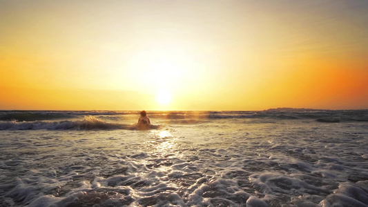 快乐的女人在日落时在海滩上玩耍视频