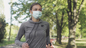 身戴保护面罩在公园内所有天气合成轨道表面跑动的健身9秒视频
