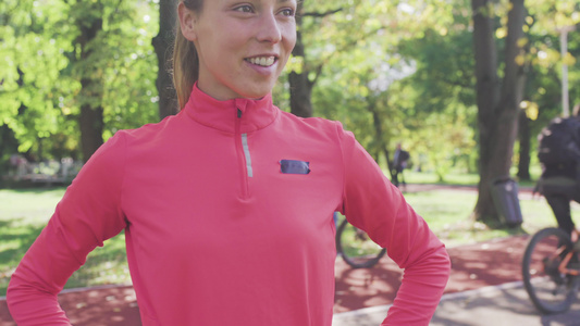身穿粉红色运动服的公园女跑步者肖像视频