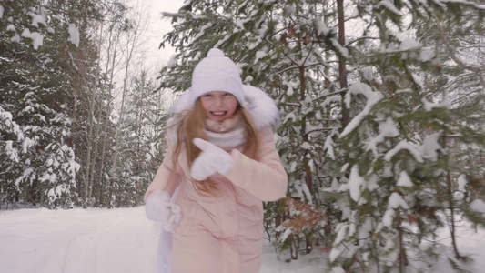 快乐的少女在雪地公园跑来跑去而冬天漫步缓慢运动视频