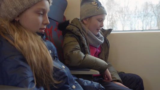 两名少女坐在乘客座位上乘坐现代列车行驶视频