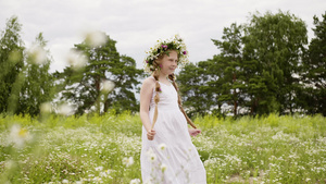 穿戴花环和白裙子的少女在花草地上10秒视频