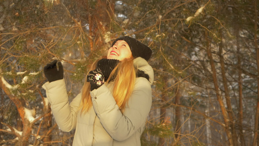 快乐的少女女孩享受冬冬松树森林下雪阳光明媚戴头罩视频