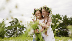 两个女孩少年在花圈与鲜花花束站在盛开的领域浪漫的女孩11秒视频