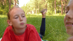 两个玩耍的少女躺在草地上在自然公园一起玩乐21秒视频