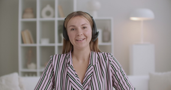 年轻女专家用麦克风无线耳机视频在家工作视频