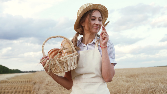 女农站在小麦农田女面包师拿着柳条篮面包生态产品烘焙视频