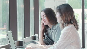 两名年轻妇女使用笔记本电脑在校园咖啡馆一起学习11秒视频