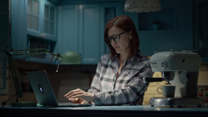 30多岁的年轻女子戴着眼镜在蓝色厨房的家里用笔记本电脑35秒视频