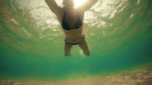 身穿比基尼的性感女性游向摄影机夏日阳光照耀时反光水下视频