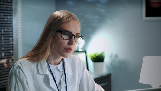 在眼镜和实验室外衣与病人进行视频通话时密切女性心理学家视频