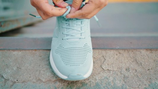 女手在运动鞋上系鞋带跑步锻炼手指运动女人将鞋带系在视频
