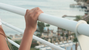 女性的手在有海景的白色栏杆阳台上26秒视频