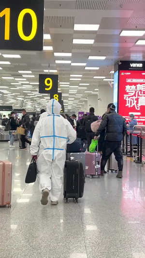 郑州新郑国际机场T2航站楼穿着防护服拉着行李箱出站的旅客穿着防护服出站的旅客19秒视频