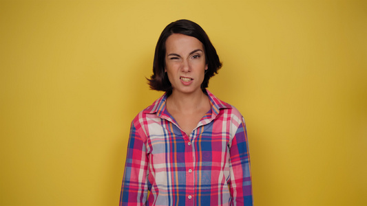 身穿黄色背景的格子衬衫的妇女有利于人类情感面部表情视频