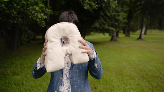 年轻人在夏天的公园里玩得开心人们用枕头写着视频