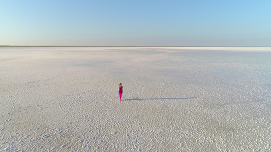 身着红裙子孤独的走在巨大的沙滩上视频