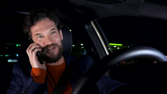 晚上快乐的男人在和城里的女朋友开着汽车在电话上聊天视频