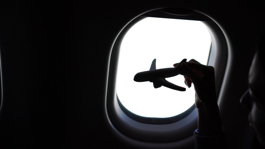 在飞机上持飞机模型玩具背景窗口的近手特紧手视频