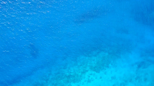 蓝海和冲浪附近的白沙背景的豪华海岸线海滩之旅的白天视频