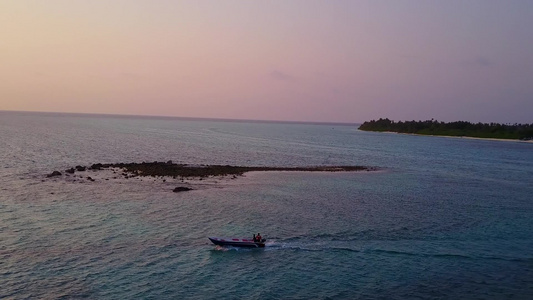 以蓝水和白色沙沙底背景在度假胜地附近航行的奇特沿海视频