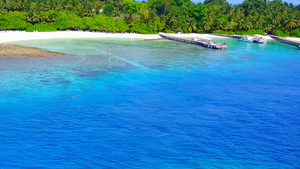 蓝水和白沙背景的礁石附近的风景13秒视频