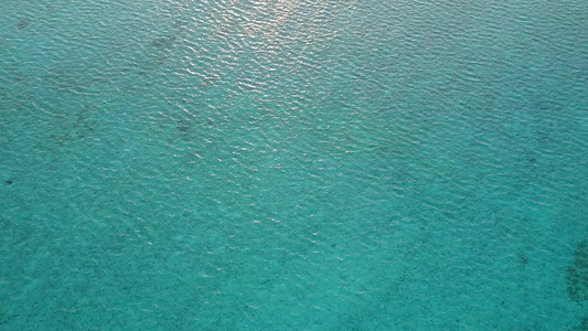 以海平面蓝海和海浪附近的白沙底背景为例观看海滨度假视频