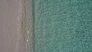 在阳光下以蓝色的海洋和白色的沙子背景关闭天堂湾海滩12秒视频