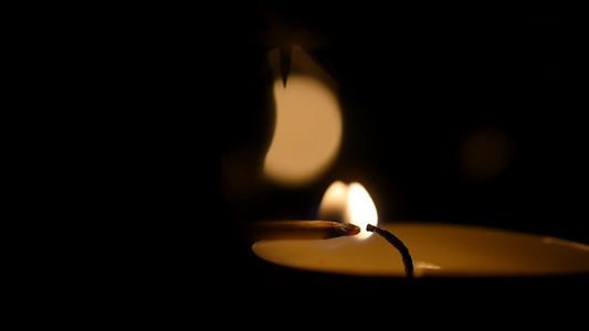 男人用火柴在庙里点燃蜡烛的黑暗慢动作蜡烛在黑暗中守夜视频