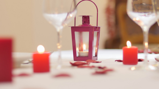服务员通过将可爱的蜡烛放在桌子上玫瑰花瓣酒杯和瓷器视频