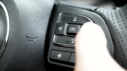 紧紧的手指按下按钮以控制驾驶方向盘上显示器上的多媒体系统视频