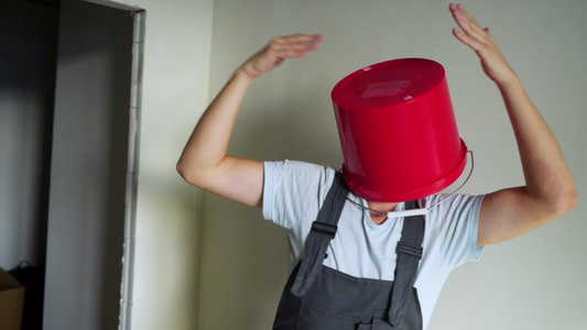 工人在单人中头顶着红色桶子玩得开心跳舞视频