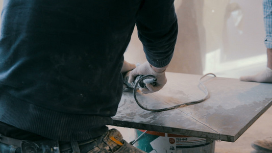在建筑工地使用角研磨机切割瓷砖的工人视频