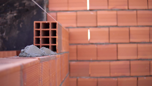 工业细节建筑瓦工工人用砖灰浆和油灰刀建造墙壁视频
