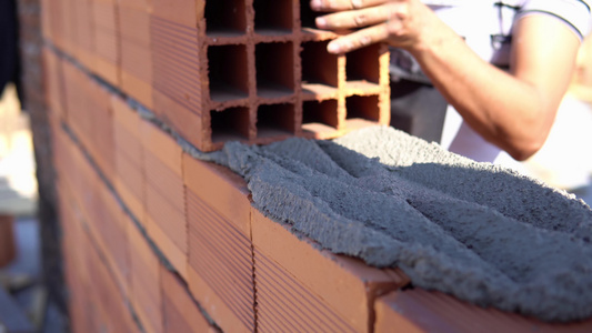 旧男人手用白洗的水泥建筑墙砖新房子视频