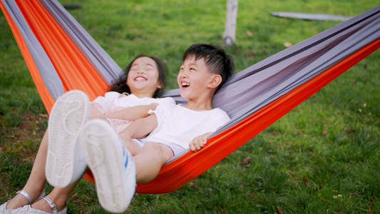 4k实拍小朋友在草地上吊床上开心玩耍视频