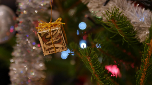 男人手在圣诞树上挂着金色的圣诞礼物圣诞礼物用彩带包装视频