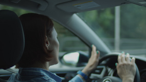 30岁的年轻女子在城市开车时跳舞和唱歌女性驾驶员用手27秒视频