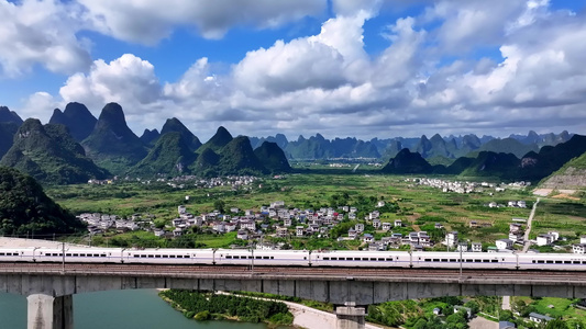 高铁桂林蓝天 穿梭在桂林山水中航拍铁轨上行驶的高铁动车快速驶过视频