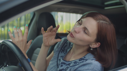 30岁的年轻女子坐在车里跳舞和唱歌观看女性驾驶员手舞视频