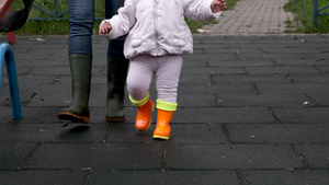 母亲和女儿穿着橡皮靴在操场散步10秒视频