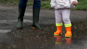 儿童橡皮橙色靴子和母亲的绿靴子15秒视频