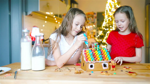 小女孩们在装饰的客厅壁炉里做圣诞姜饼屋17秒视频