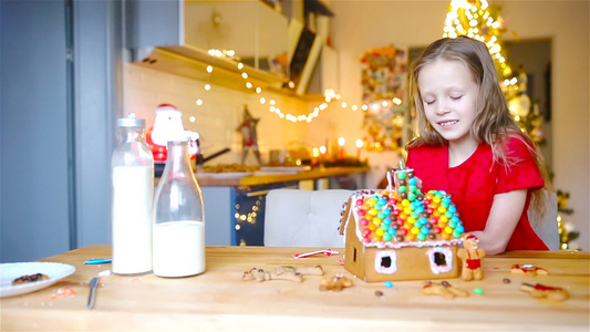 小女孩们在装饰的客厅壁炉里做圣诞姜饼屋视频