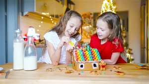 小女孩们在装饰的客厅壁炉里做圣诞姜饼屋29秒视频