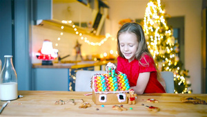 小女孩们在装饰的客厅壁炉里做圣诞姜饼屋7秒视频