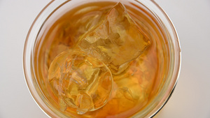 威士忌玻璃杯的顶部视图有冰块旋转12秒视频